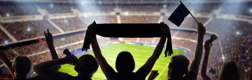 Fans mit Schals und Fahnen unterstützen ihre Mannschaft im Stadion.