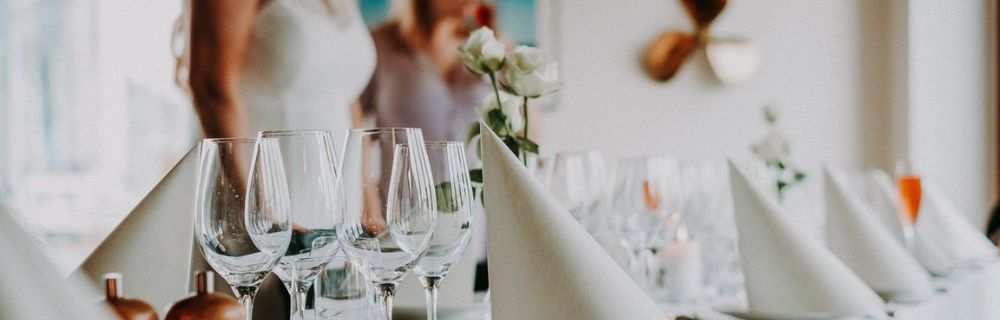 Festlich gedeckter Hochzeitstisch mit Gläsern, Servietten und Blumendekoration.