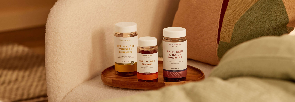 Vitamin-Gummies für Gesundheit und Pflege dekorativ auf einem Holztablett platziert.